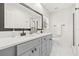 Modern bathroom with dual sinks, white countertops, framed mirror, and glass-enclosed shower at 1713 W Saint John St, Tampa, FL 33607