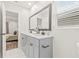 Bathroom featuring white countertops, framed mirror, and gray cabinets with black hardware at 1713 W Saint John St, Tampa, FL 33607