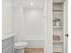 Full bathroom with shower-tub combination with white tile surround and built-in storage shelves at 1713 W Saint John St, Tampa, FL 33607