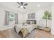 Cozy bedroom with natural light, featuring wood floors, ceiling fan, and a queen-sized bed at 1713 W Saint John St, Tampa, FL 33607