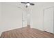 Empty bedroom with wood-look floors, fan, closet, and open door to another room at 1713 W Saint John St, Tampa, FL 33607