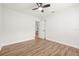 Empty bedroom with hardwood floors, ceiling fan, and view into adjacent living area at 1713 W Saint John St, Tampa, FL 33607