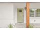 Charming front porch with a vibrant green door and decorative wood post at 1713 W Saint John St, Tampa, FL 33607