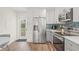 Updated kitchen with stainless steel appliances, white cabinets, and a convenient side entrance at 1713 W Saint John St, Tampa, FL 33607