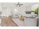 Bright living room features a ceiling fan, wood-look flooring, a cozy sectional, and a stylish rug at 1713 W Saint John St, Tampa, FL 33607