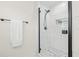 Modern glass enclosed shower featuring black hardware, white marble tile, and mosaic tile floor at 1713 W Saint John St, Tampa, FL 33607