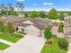 An aerial view of a well-landscaped home with a brick patio nestled among mature trees and neighboring houses at 18620 Rococo Rd, Spring Hill, FL 34610