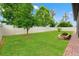Lush backyard with well-kept lawn, landscaping features, and a white privacy fence surrounding the property at 18620 Rococo Rd, Spring Hill, FL 34610