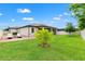 Spacious backyard featuring lush green grass, a brick patio with lounge chairs, and privacy fencing at 18620 Rococo Rd, Spring Hill, FL 34610