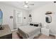 Bright bedroom features a ceiling fan, gray patterned bedding, and modern decor at 18620 Rococo Rd, Spring Hill, FL 34610