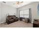 Cozy bedroom features a ceiling fan, reclining sofa, and built-in desk at 18620 Rococo Rd, Spring Hill, FL 34610