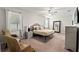 Cozy bedroom features comfortable bedding, neutral decor, accent chairs, and a large window for natural light at 18620 Rococo Rd, Spring Hill, FL 34610