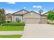 Charming single Gathering home featuring a well-manicured lawn and a spacious three-car garage at 18620 Rococo Rd, Spring Hill, FL 34610