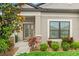 Inviting front entrance with a decorative glass door and colorful landscaping enhances curb appeal at 18620 Rococo Rd, Spring Hill, FL 34610