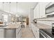 Open kitchen featuring granite countertops, white cabinets, and stainless steel appliances, seamlessly flowing into the living room at 18620 Rococo Rd, Spring Hill, FL 34610