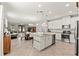 Bright, open kitchen with an island, white cabinetry, and stainless steel appliances seamlessly connected to the living area at 18620 Rococo Rd, Spring Hill, FL 34610