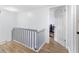Bright hallway featuring wood-look floors and white staircase leading to an open door at 1881 N Hercules Ave # 602, Clearwater, FL 33765