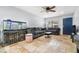 Open-concept living room featuring an aquarium, travertine floors, and a comfortable grey sofa at 1881 N Hercules Ave # 602, Clearwater, FL 33765