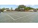 Enjoy a game of tennis on the community court with lovely landscaping and a clubhouse in the background at 1881 N Hercules Ave # 602, Clearwater, FL 33765