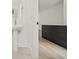 Compact bathroom with a pedestal sink and doorway leading into a room with wood-style flooring at 321 15Th N St, St Petersburg, FL 33705