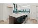 Modern kitchen boasts white cabinets, stainless steel appliances, island with seating, and a unique green tile backsplash at 321 15Th N St, St Petersburg, FL 33705