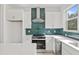 Bright kitchen featuring sleek white cabinets, green backsplash, and stainless steel appliances at 321 15Th N St, St Petersburg, FL 33705