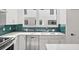 Stylish kitchen showcasing green backsplash, stainless steel appliances, and white countertops at 321 15Th N St, St Petersburg, FL 33705
