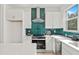 Bright kitchen featuring sleek white cabinets, green backsplash, and stainless steel appliances at 321 15Th N St, St Petersburg, FL 33705