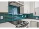 Close up of a modern kitchen showcasing green backsplash, stainless steel appliances, and white countertops at 321 15Th N St, St Petersburg, FL 33705