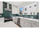 Bright kitchen showcasing green backsplash, stainless steel appliances, and white countertops at 321 15Th N St, St Petersburg, FL 33705