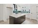 Open concept kitchen features a dark island, white cabinetry, stainless steel appliances and green backsplash at 321 15Th N St, St Petersburg, FL 33705