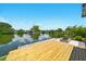 Waterfront backyard with wood deck and firepit, perfect for enjoying serene lake views and outdoor relaxation at 3312 Holly Springs Dr, Hernando Beach, FL 34607