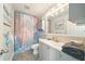 Charming bathroom with modern fixtures, vanity, stylish lighting, and seashell themed shower curtain at 3312 Holly Springs Dr, Hernando Beach, FL 34607