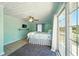 Light and airy bedroom features wooden floors, ceiling fan, television, and balcony access at 3312 Holly Springs Dr, Hernando Beach, FL 34607