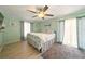 Light and airy bedroom features wooden floors, ceiling fan, and access to an outdoor balcony at 3312 Holly Springs Dr, Hernando Beach, FL 34607