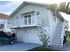 Two-story coastal home featuring a balcony, two-car garage, and stairs to the main level at 3312 Holly Springs Dr, Hernando Beach, FL 34607