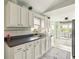 Bright kitchen with white cabinetry, sleek countertops, modern appliances, and outdoor access at 3312 Holly Springs Dr, Hernando Beach, FL 34607