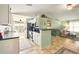Open kitchen with white cabinets, modern appliances, breakfast bar, and adjacent living space at 3312 Holly Springs Dr, Hernando Beach, FL 34607