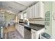 Kitchen featuring white cabinets, dark countertops, and stainless steel dishwasher and sink at 3312 Holly Springs Dr, Hernando Beach, FL 34607