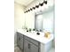 Modern bathroom with double vanity, gray cabinets, large mirror, and contemporary fixtures at 33560 Castaway Loop, Wesley Chapel, FL 33543