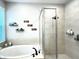 Modern bathroom showcasing a soaking tub, frameless shower, and elegant fixtures at 33560 Castaway Loop, Wesley Chapel, FL 33543