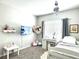 Bedroom featuring a comfortable bed, desk with chair, and a window with blinds at 33560 Castaway Loop, Wesley Chapel, FL 33543