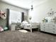 Carpeted bedroom featuring a large window, white dresser, and a comfortable bed at 33560 Castaway Loop, Wesley Chapel, FL 33543