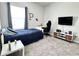 Bright bedroom with a single bed, gray carpet, a TV and white desk at 33560 Castaway Loop, Wesley Chapel, FL 33543