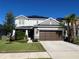 Two-story home boasts a well-manicured lawn, palm trees, a two-car garage and solar panels at 33560 Castaway Loop, Wesley Chapel, FL 33543