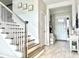 Bright foyer featuring gray and white staircase, neutral walls, and light hardwood floors at 33560 Castaway Loop, Wesley Chapel, FL 33543