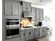 Bright kitchen boasts gray cabinets, stainless steel appliances, and stylish backsplash at 33560 Castaway Loop, Wesley Chapel, FL 33543