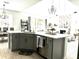Open kitchen featuring a central island with gray cabinets, quartz countertops, and stainless steel appliances at 33560 Castaway Loop, Wesley Chapel, FL 33543