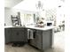 Modern kitchen featuring a central island with gray cabinets, a fireplace, and stainless steel appliances at 33560 Castaway Loop, Wesley Chapel, FL 33543