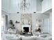 Bright living room with tall ceilings, fireplace, modern chandelier, and neutral decor at 33560 Castaway Loop, Wesley Chapel, FL 33543